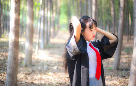 A girl in a bachelor's suit in the woodsの写真素材