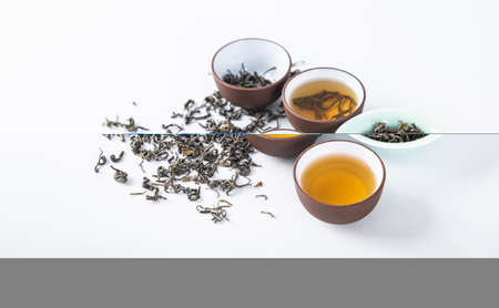 Tea leaves and tea set on a white backgroundの写真素材