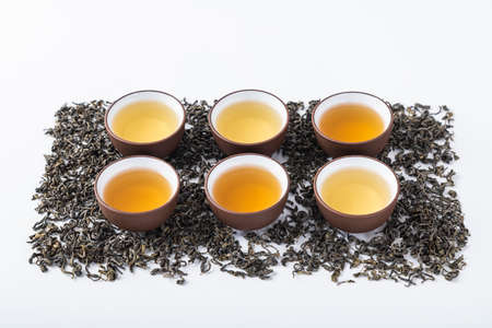 Tea leaves and tea set on a white backgroundの写真素材