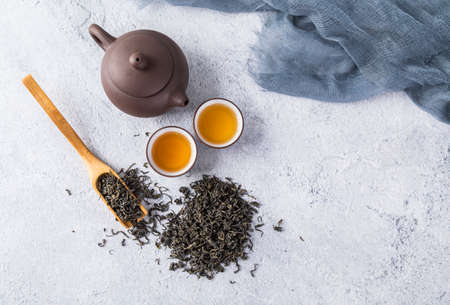 Tea leaves and tea set on a white backgroundの写真素材