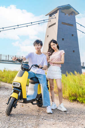 Young couple traveling by electric scooterの写真素材