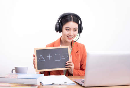 Asian female teacher with earphones teaching online class, online education