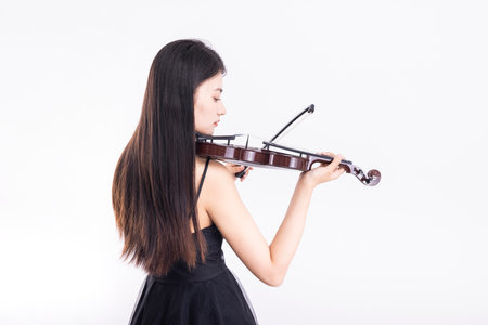 Beautiful asian woman playing violin on white background, asian modelの写真素材