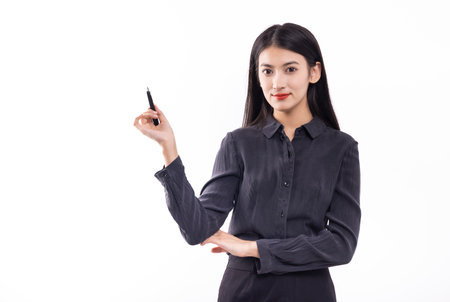 Asian business woman holding a pen and writing something isolated on white backgroundの写真素材