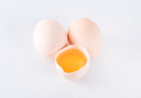 Egg yolk in eggshell isolated on a white background.