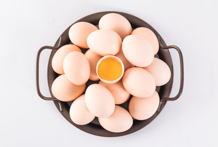 Chicken eggs in a bowl on a white background. Top view.