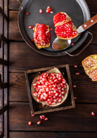 Pomegranate fruit on wooden background, top view, verticalの写真素材
