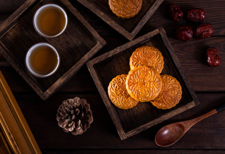 Moon cakes for Mid-Autumn Festival on wooden tray with tea.の写真素材