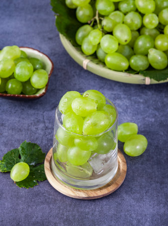 Fresh green grapes in a glass on a dark background. Selective focus.の写真素材