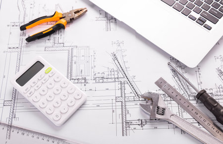 Architectural plans with calculator, tools and laptop on architectural projectの写真素材