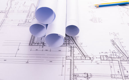 Architectural blueprints with blueprints rolls on the desk.