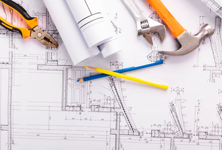 Architectural plans and rolls of blueprints with construction tools.の写真素材
