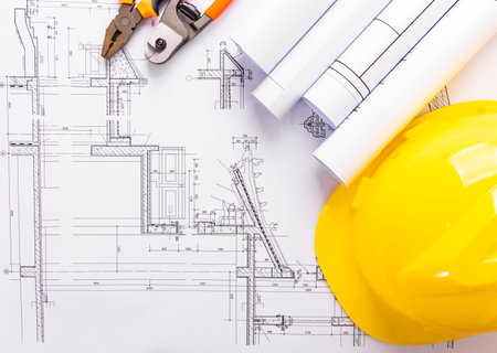 Architectural plans and yellow helmet on the background of construction drawingsの写真素材