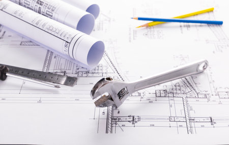 Architectural plans and rolls of blueprints with a spannerの写真素材