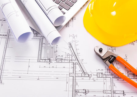 Architecture blueprints with yellow helmet and pliers on deskの写真素材