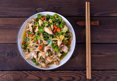 Stir-fried chicken with vegetables and mushrooms in a bowl on wooden backgroundの写真素材
