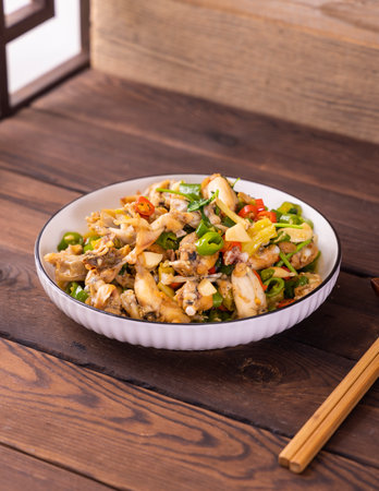 Stir fried squid with vegetables in a bowl on wooden table.の写真素材