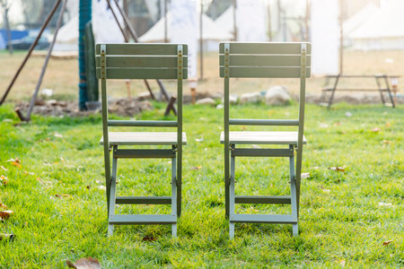 Two chairs on green grass in the garden, vintage tone.の写真素材