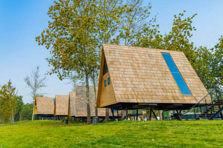 Modern wooden house on the green grass and blue sky in sunny dayの写真素材