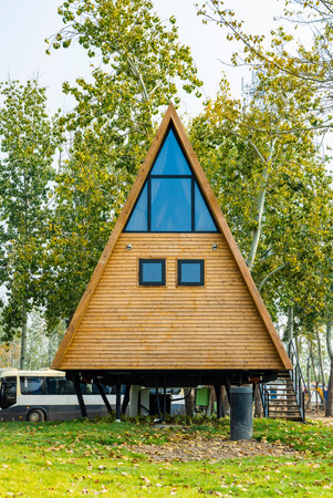 Wooden house in the park on a background of autumn trees.の写真素材