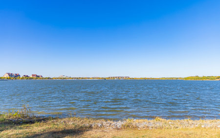 Landscape view of lake with blue sky and white clouds on sunny dayの写真素材