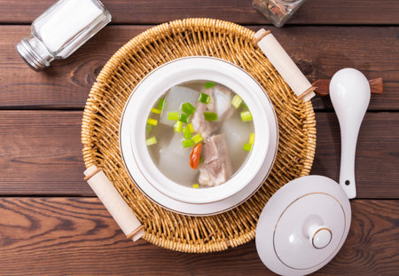 Chicken soup with vegetables in a bowl on a wooden table. Top viewの写真素材