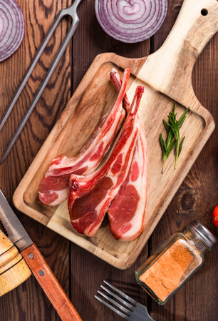 Raw lamb chops on cutting board with spices and herbs. Top viewの写真素材