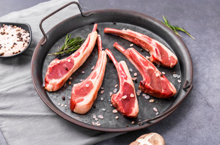Raw lamb chops with spices and herbs in a cast-iron panの写真素材