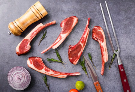 Raw lamb chops with rosemary and spices on a stone background. Top viewの写真素材