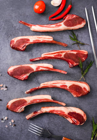 Raw lamb chops with rosemary and spices on a stone background. Selective focus.の写真素材