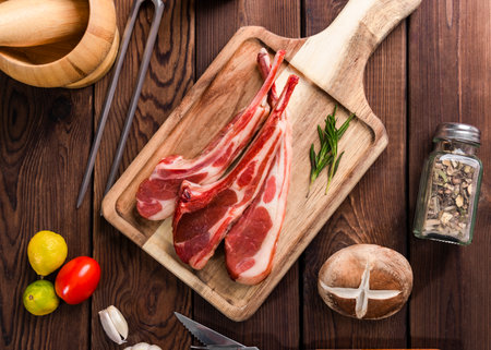Raw lamb chops with ingredients for cooking on wooden board. Top viewの写真素材