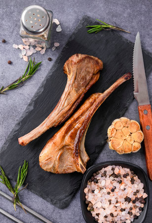 Grilled lamb chops with herbs and spices on slate board, top viewの写真素材