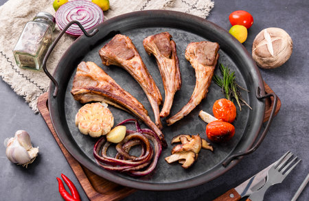 Grilled lamb chops with onion, garlic and tomato on cast-iron panの写真素材