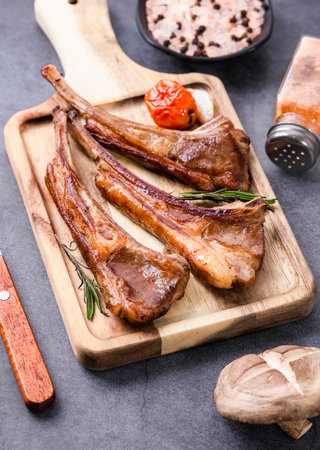 Grilled lamb chops on wooden cutting board, top view, copy spaceの写真素材