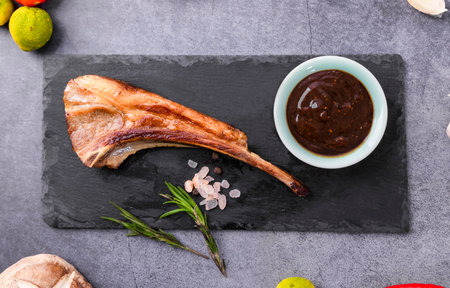 Grilled lamb chop with barbecue sauce on slate board. Top viewの写真素材