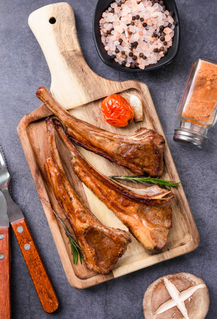 Grilled lamb ribs with spices and herbs on cutting board, top viewの写真素材