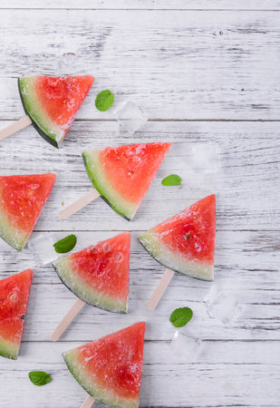Slices of watermelon with mint leaves on wooden background.の写真素材