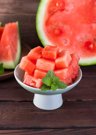 Slices of watermelon in a bowl on a wooden backgroundの写真素材