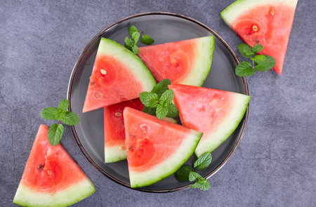 Slices of watermelon with mint on a gray background.の写真素材