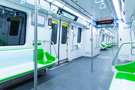 Interior of a modern subway car with green seats and electric lightsの写真素材