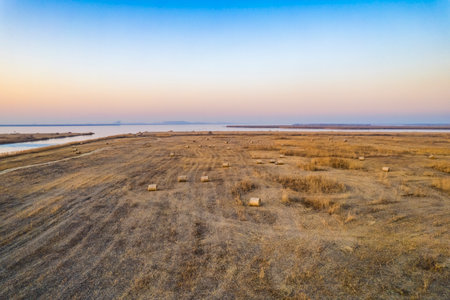 Sunset over the salt lake with straw bales in the foregroundの写真素材