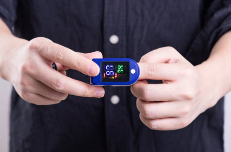 Close up of a man using a pulse oximeter to measure blood pressureの写真素材