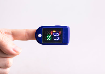 Hand holding digital non-contact pulse oximeter isolated on white backgroundの写真素材