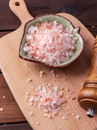 Himalayan pink salt in bowl on wooden background. Top viewの写真素材