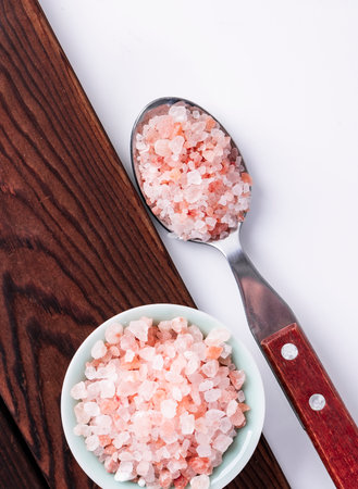 Pink himalayan salt in a bowl and spoon on wooden backgroundの写真素材