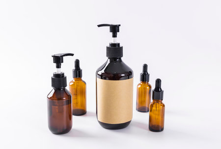 Mockup of brown glass cosmetic bottles with blank label on white backgroundの写真素材