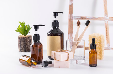 Eco-friendly bathroom accessories. Natural soap, shampoo, bamboo toothbrushes, bottles of liquid soap on white backgroundの写真素材