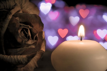 Candle with rose flower on bokeh hearts background. Vintage style.の写真素材