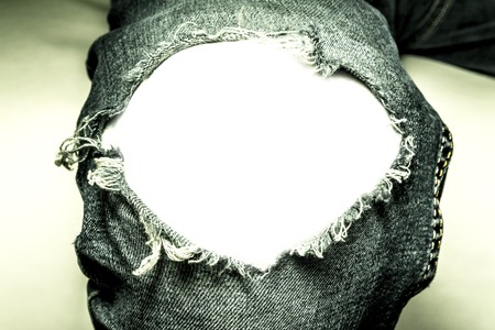 Hole on his knee in black jeans close-up with isolated white background for textの写真素材