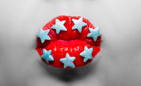 Black and white portrait woman with lips painted red lipstick and candy stars macro. Kiss to the camera.の写真素材